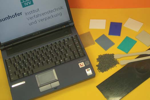 Laptop und Einzelteile vor orangefarbenem Hintergrund