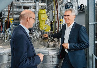 Dr. Andreas Mäurer und Dr. Martin Schlummer im Technikum Kunststoffrecycling vor einem Reaktor