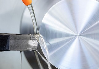 Metallene Maschine zum Einsatz von wasserbasierten Schmierstoffalternativen mithilfe eines orangenen Schlauchs