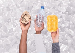 Drei Hände halten verschiedene Recycling-Verpackungen hoch