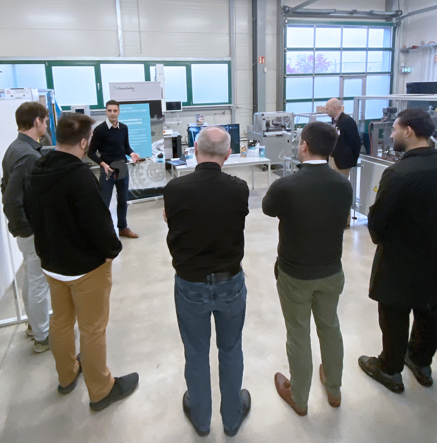 Teilnehmende der Veranstaltung Zukunftstage: Future Clean 2024 verfolgen in einem Technikum einer Demonstration eines digitalen Reinigungsassistenten.