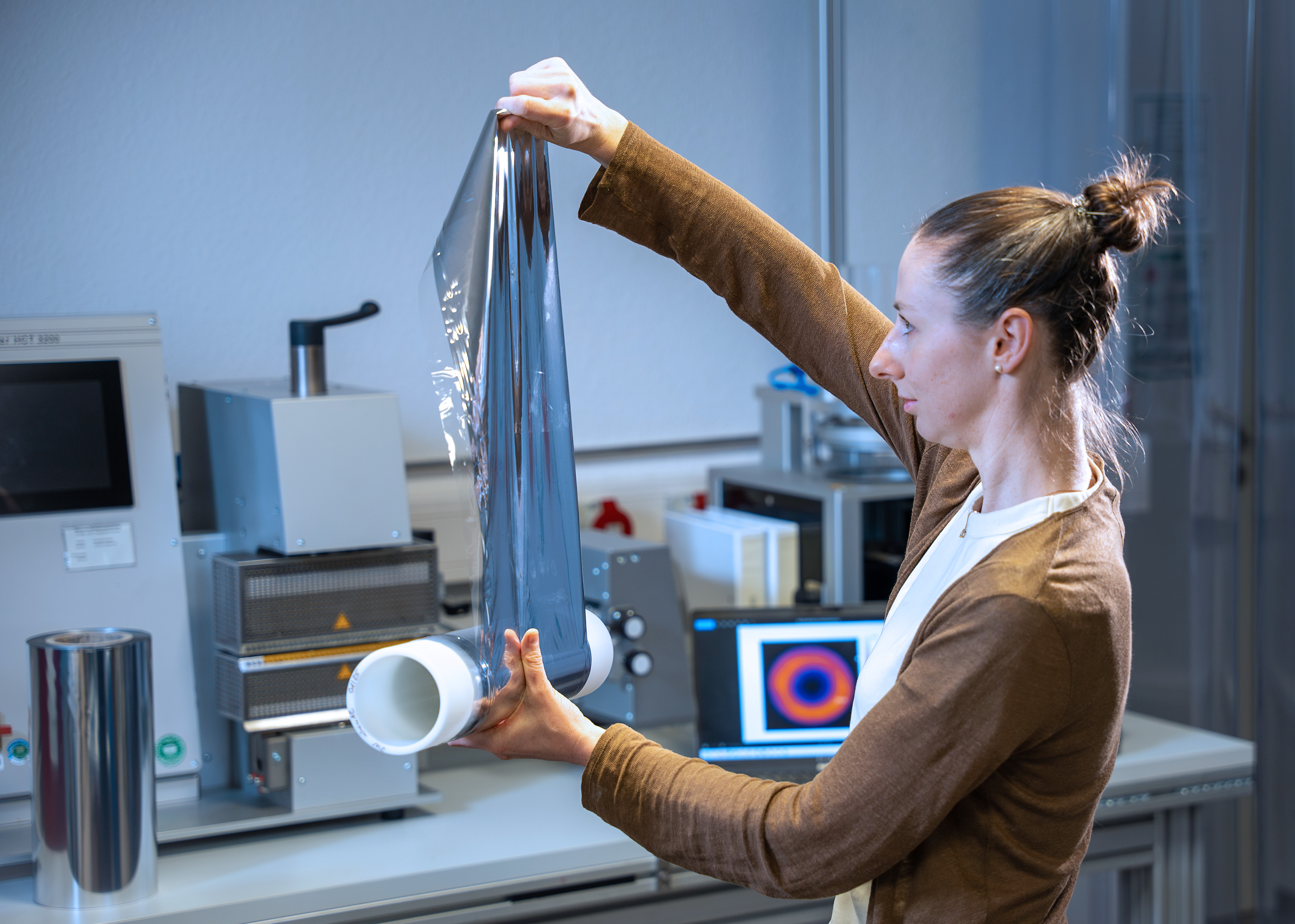Eine Wissenschaftlerin prüft aluminiumbeschichtete Folie, die bei der Herstellung von Beutelverpackungen verwendet wird.