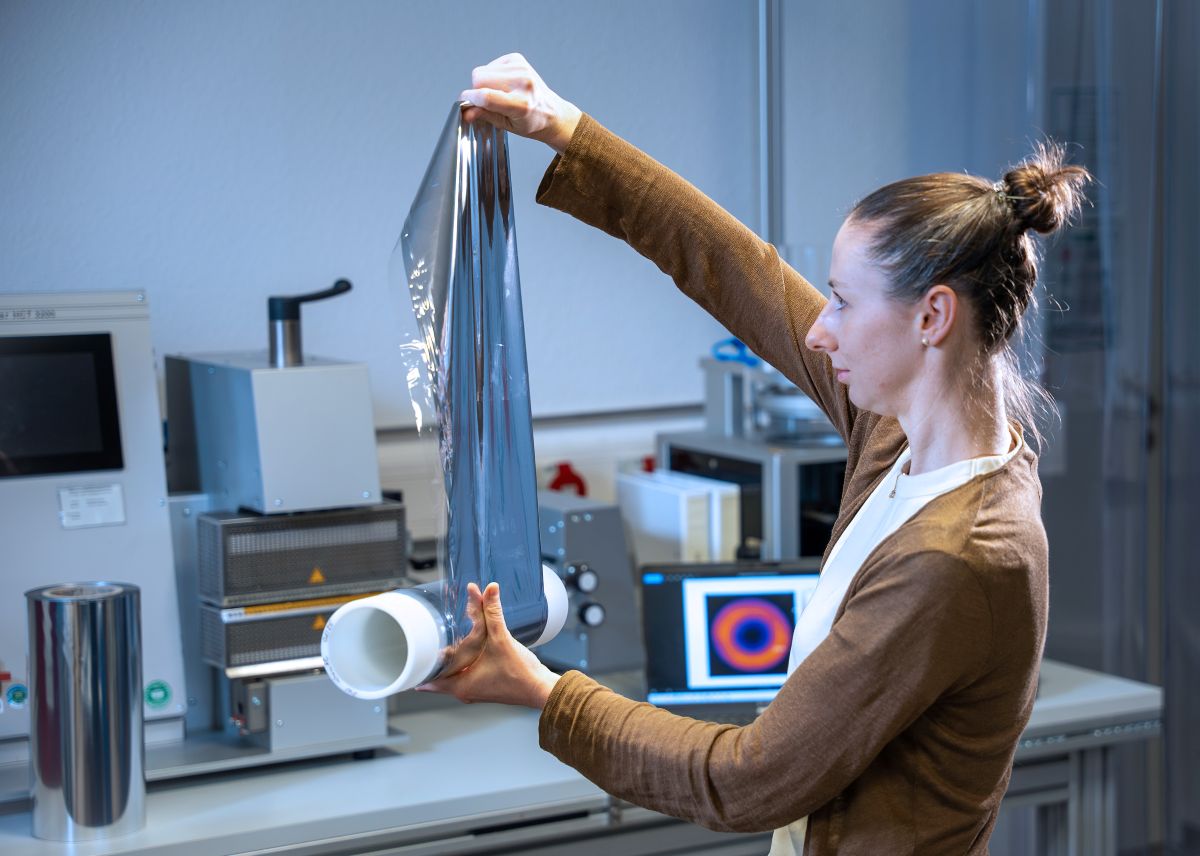 Induktionssiegelprozess für recyclingfähige Packstoffe - mInimAL Eine Wissenschaftlerin betrachtet eine aluminiumbedampften Folie zur Herstellung von Beutelverpackungen