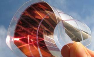 Organische Solarzelle wird mit einer Hand gebogen in die Luft gehalten