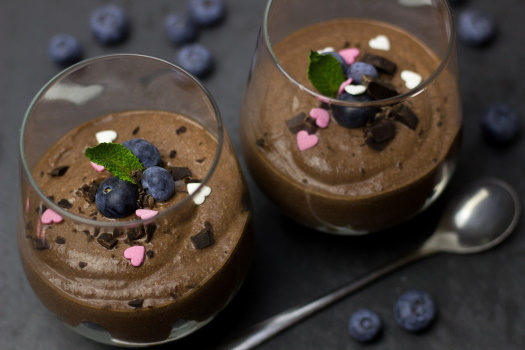 Reduced fat content in desserts due to microparticulation Reduced fat mousse au chocolat with blueberries filled in glasses