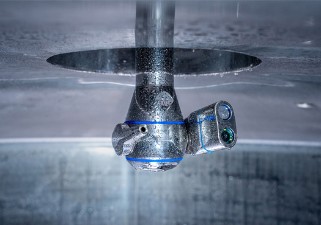 AJCsens - Inline-Monitoring durch hochintegrierten Verschmutzungssensor in adaptivem Zielstrahlreiniger Abbildung des Reinigungskopfes des AJCsens mit dem hochintegrierten Sensor in einem Tank.