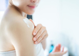 Frau cremt ihren Arm ein