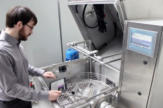Man operates model system for component cleaning.