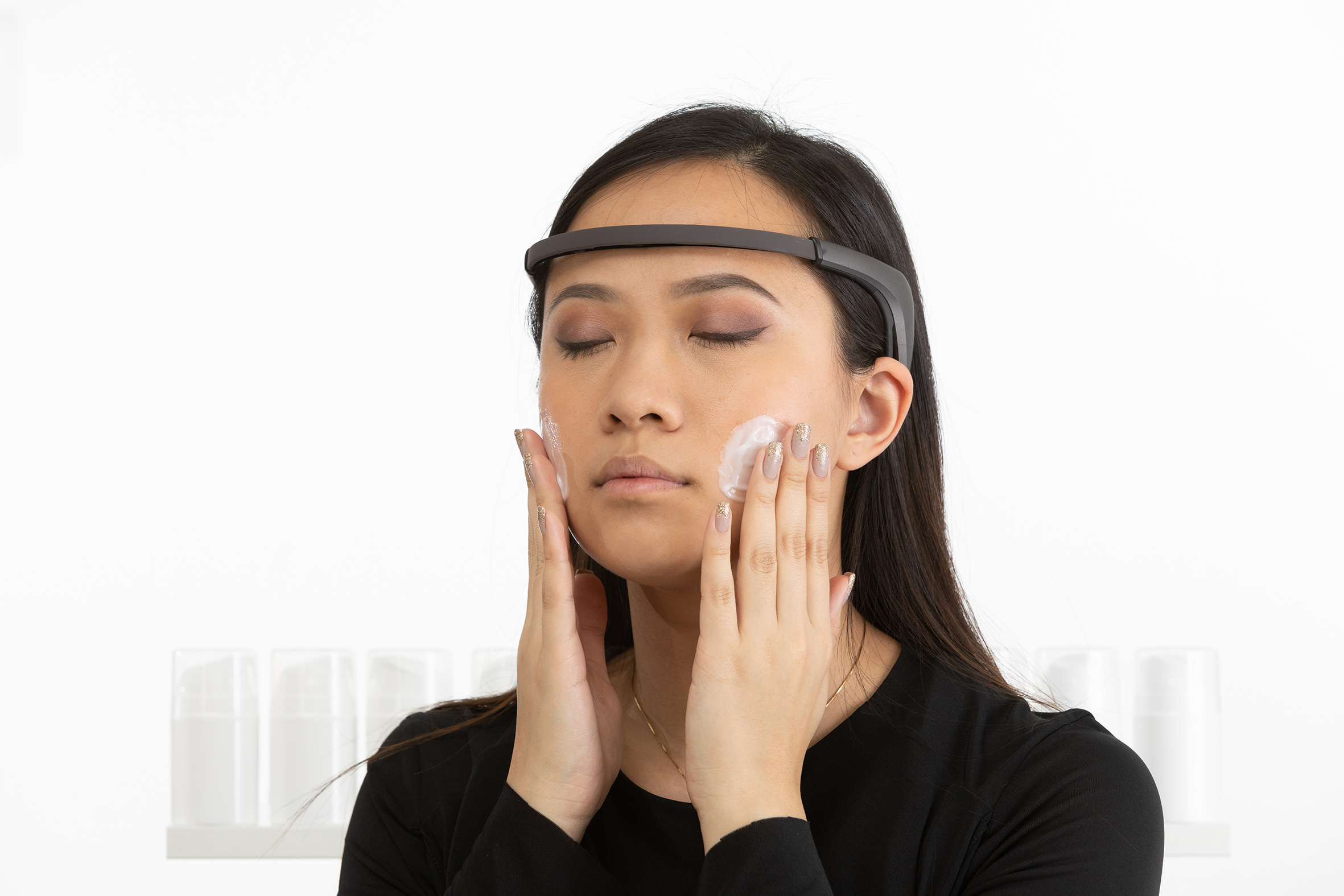 EEG headband measures the brain activity of a woman applying cream to her cheeks