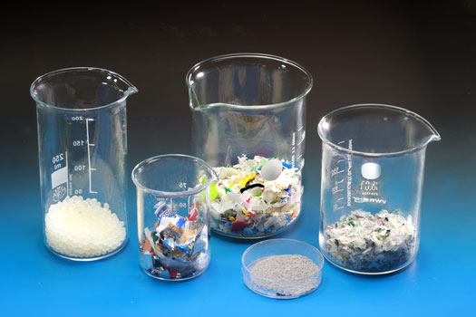 Shredded plastic recyclates in various laboratory glasses